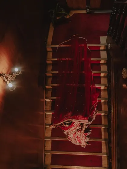 An artistic top-down shot of the bride's red lehenga laid out on a staircase.