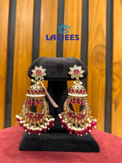 Classic jhumka-style earrings with a floral top and red beadwork, a timeless piece for your collection.
