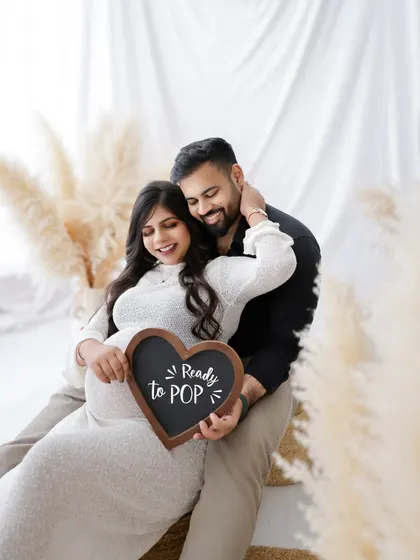 "Ready to POP!" This fun and happy couple's portrait uses a cute sign to add a playful touch to their maternity photos.