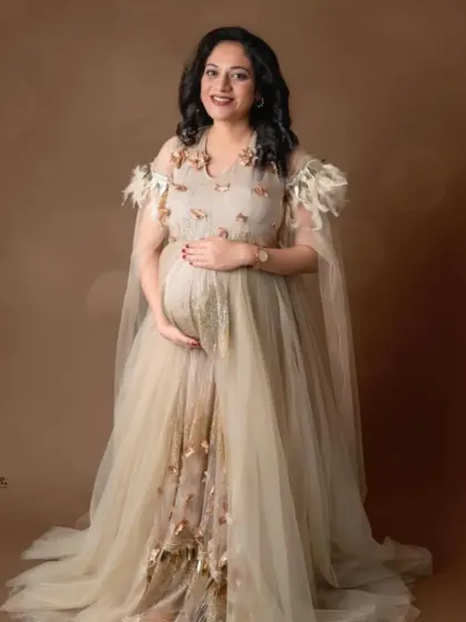 A full-length portrait in our elegant beige gown with a sheer cape and delicate embellishments, perfect for a sophisticated look.