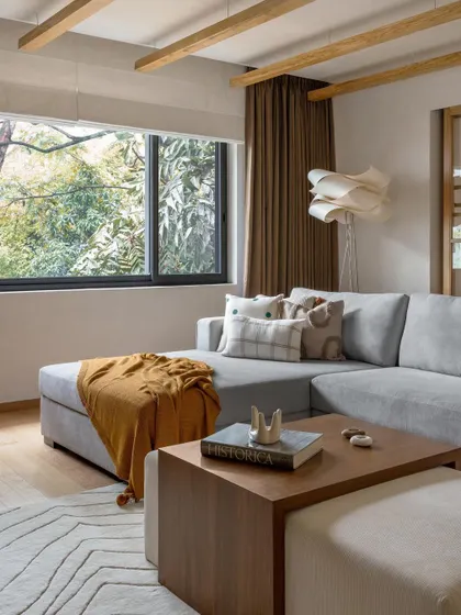 A look back at our projects from 2023. This living room showcases a cozy sectional and a large window framing a beautiful view, embodying our warm minimal style.