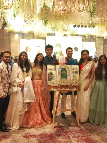 The friends who gifted the live painting experience pose with the finished artwork. It’s a truly unique and memorable wedding gift that everyone can be a part of.