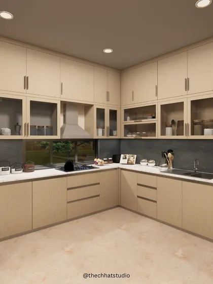 This L-shaped kitchen is designed for maximum efficiency and style. The light wood cabinets, some with frosted glass fronts, provide ample storage, while the large window over the sink offers a pleasant view and natural light.