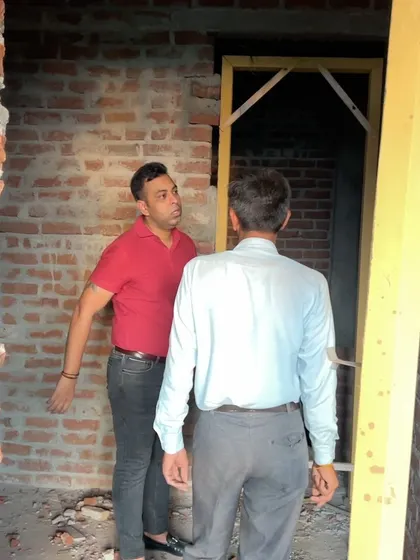 Giving clear instructions on-site is key. I am discussing the precise details for a door frame installation with my lead mason.