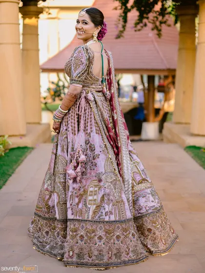 A beautiful back shot showcasing the bride's elegant hairstyle and the intricate details of her blouse and lehenga.