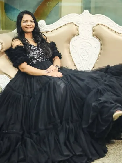 The client seated in the black gown, showcasing its volume and texture.