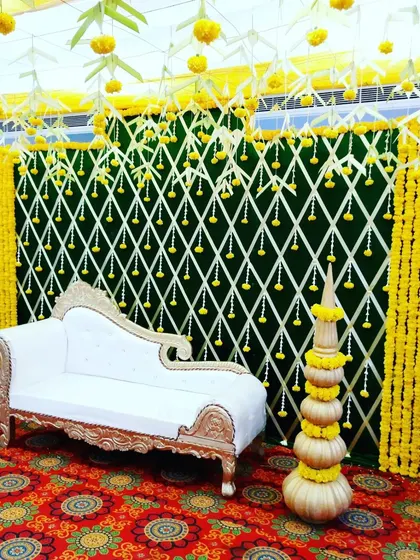 This close-up of the mandap stage shows the details of the marigold backdrop and the traditional brass pots. The design is both grand and full of intricate, culturally significant elements.