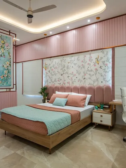A wide view of the Indian contemporary daughter's bedroom, showing the integrated study area, the statement art partition, and the cohesive pink and pastel color scheme. The room is designed to be both inspiring and restful.