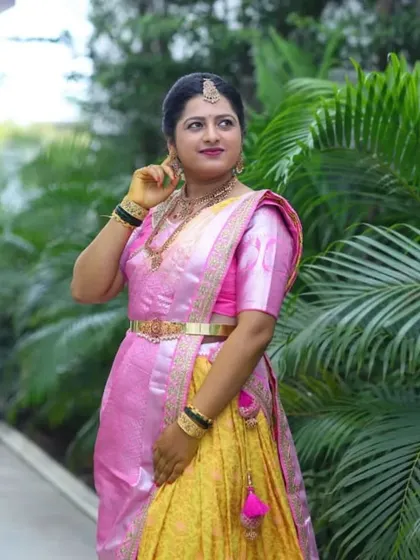 A beautiful look for a half-saree function. The client is wearing a lovely pink and yellow langa davani, and her makeup is kept fresh and bright to match the festive occasion.