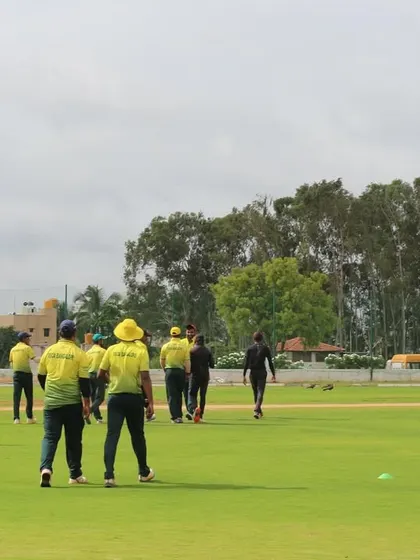 Players returning to their positions on the field, highlighting the large and well-maintained playing area.