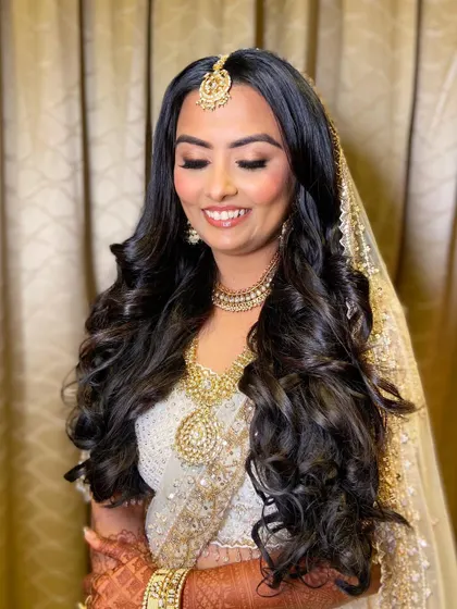 A close-up of Bansi's wedding makeup. The soft pink and gold eyeshadow blend seamlessly, paired with voluminous lashes for a romantic and dreamy effect.