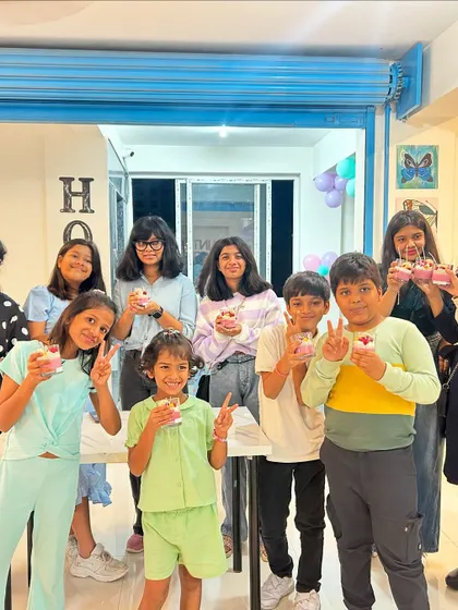 A group of kids having fun and showing off their finished cupcake candles.