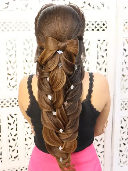 A beautiful mermaid braid hairstyle with a bow element. This is a popular and trendy style for younger clients, perfect for parties and special events.