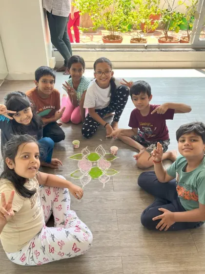 Teamwork makes the dream work! A group of children collaborates on a beautiful rangoli, learning the values of cooperation and shared creativity at our Bala Shivir.