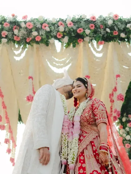A sweet kiss on the cheek under the mandap. This candid moment captures the affection and happiness of the newlyweds.