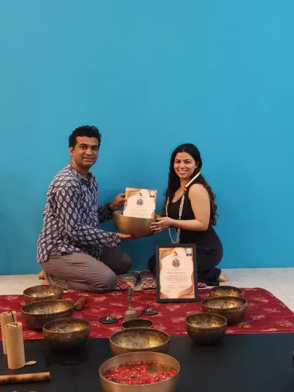 A student smiles as she receives her Sound Healing certification, ready to share the power of vibrational medicine.