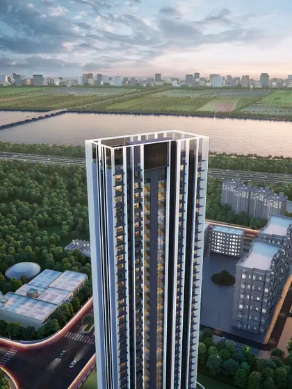 An aerial perspective of the sustainable luxury tower, highlighting its slender profile and relationship to the surrounding green spaces and waterways. The design emphasizes a harmonious blend of urban living and nature.
