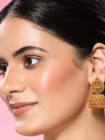 A classic gold jhumka earring is the focus of this shot, appealing to customers looking for timeless ethnic pieces.