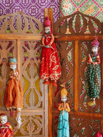 A collection of traditional Rajasthani puppets ('kathputli') used as a decorative element, celebrating the region's vibrant folk art traditions.