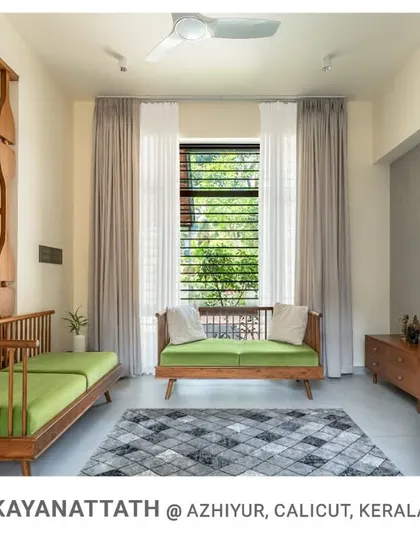 The full living space at Kayanattath, where light from the window and the adjacent courtyard fills the room. The design uses minimal furniture to maintain a sense of openness.