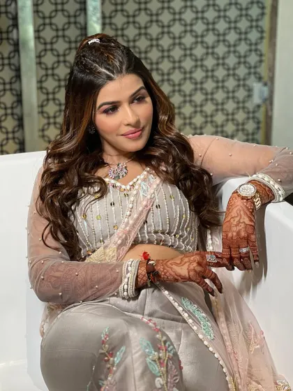 The bride relaxing in a modern setting, her playful yet glamorous makeup looking absolutely flawless. The soft waves in her hair complete the look.