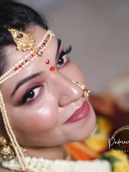 This is a classic Maharashtrian bridal look, complete with the traditional 'mundavalya' and nose ring. I used a smokey eye with a soft pink lip to create a modern yet authentic look for her special day.