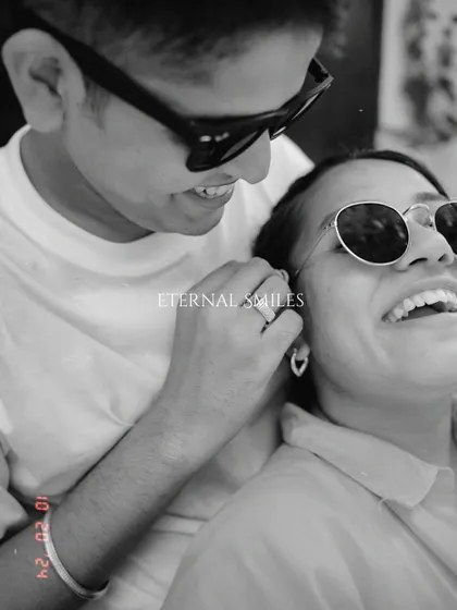 A playful, candid moment from a pre-wedding shoot. Their sunglasses and wide smiles capture a cool, modern love story that is full of fun and laughter.