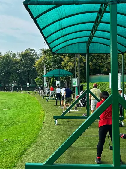 A view from one of the covered bays, looking out onto the expansive range where golfers are enjoying their Saturday swings.