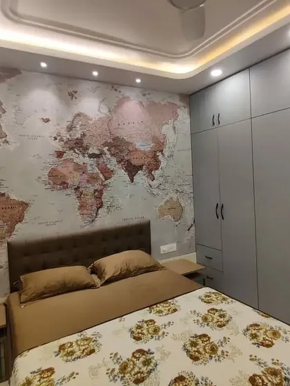 We designed this bedroom as a complete experience, centered around a striking world map statement wall for our travel-loving client. The design integrates floor-to-ceiling matte grey wardrobes for ample storage, a comfortable tufted headboard, and multi-level ceiling cove lighting to create a warm, inviting atmosphere.
