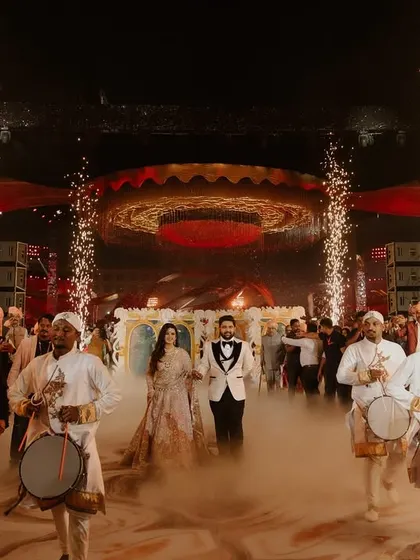A royal welcome for the couple at their reception. They enter through a path of cold pyros, led by drummers, creating a grand and energetic start to the evening.