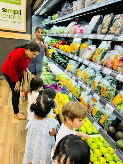 Children explore the vegetable aisle at the supermarket, pointing out familiar and new vegetables.