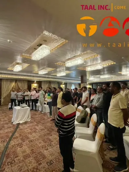 A group of employees standing and engaging in a rhythm activity. Our sessions often include movement to get the energy flowing.