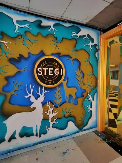 The entrance mural for Stegi Bangalore, featuring a layered forest scene with deer silhouettes and the bar's logo at the center.