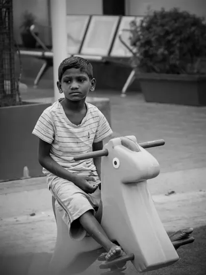 Another candid shot from the park, this time of a boy on a rocking horse. These unposed moments are often the most precious memories for families.