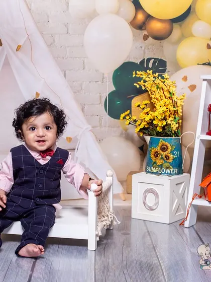 A stylish first birthday setup with a boho feel. The combination of a miniature bed, lanterns, and a guitar created a cool and relaxed vibe for this little boy's milestone session.
