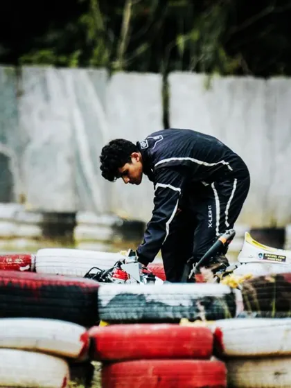 A driver making an adjustment to his kart after a spin.