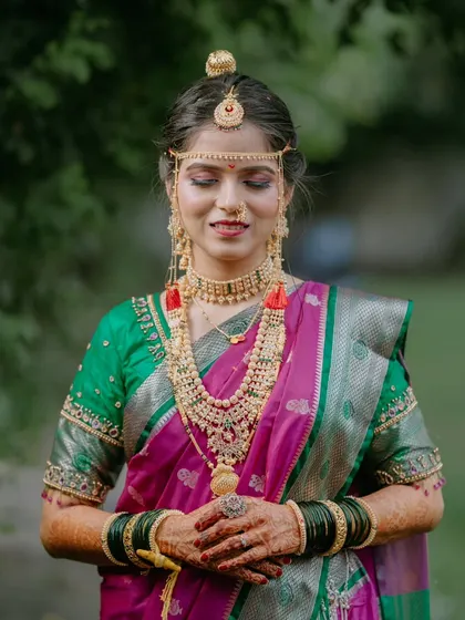A serene portrait of a Maharashtrian bride with her eyes closed, highlighting her stunning layered necklaces and traditional accessories.