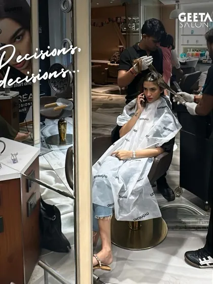 Decisions, decisions. A client on the phone while her colour is being applied, a common sight during the transformation process.