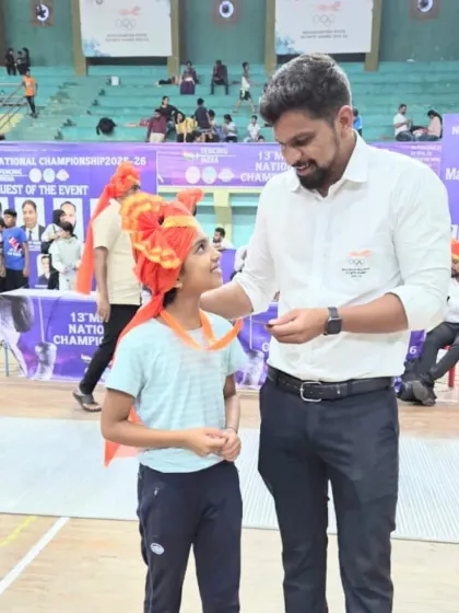 I am seen here congratulating Arnavi Dhapsay after her bronze medal win at the U-10 National Championship. It is a special moment between a coach and a young, promising athlete.