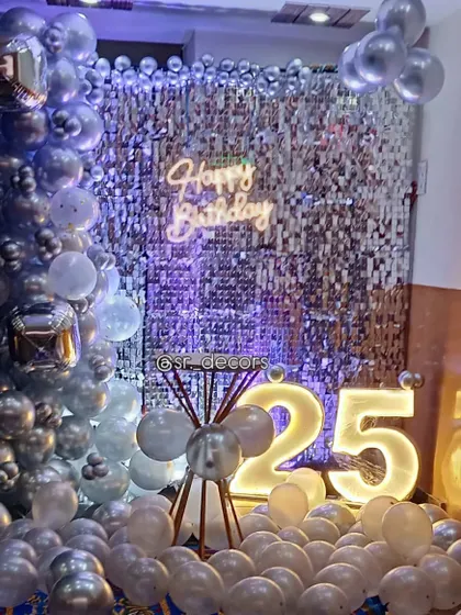Different colored lighting can be used to match the party's theme, as shown in this purple-lit version of the 25th birthday decor.