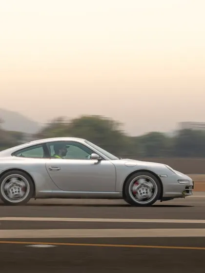 This panning shot of a silver Porsche 911 captures its classic lines while conveying a strong sense of speed and movement.