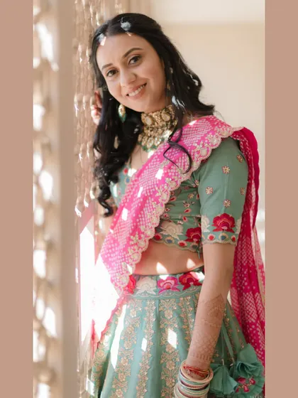 A bright and happy bridal portrait. The bride's smile lights up the frame, and her colorful lehenga adds to the joyful mood.
