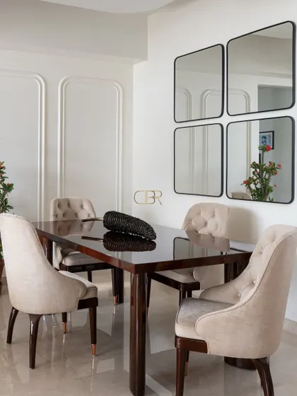 The dining area is where families come together, and I designed this space to feel both elegant and welcoming. The clean lines of the dark wood table are softened by upholstered chairs and the strategic use of mirrors, which expand the space and reflect light, creating an intimate setting for shared meals.
