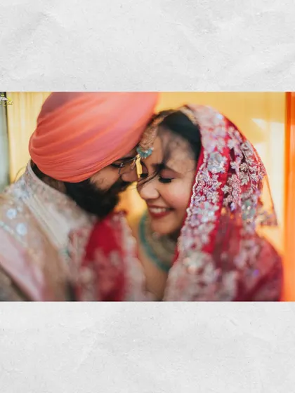An intimate moment from a Sikh wedding. The couple's gentle touch and happy smiles capture the deep love and devotion celebrated during the Anand Karaj ceremony.