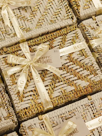 A sea of our white and gold woven boxes, each tied with a custom ribbon for a corporate client. This is what bulk festive gifting looks like at our workshop.