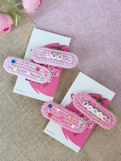 These sweet pink crochet clips, personalized for Eva and Farah, are perfect for any occasion. One clip features the name, and the other has matching heart beads.