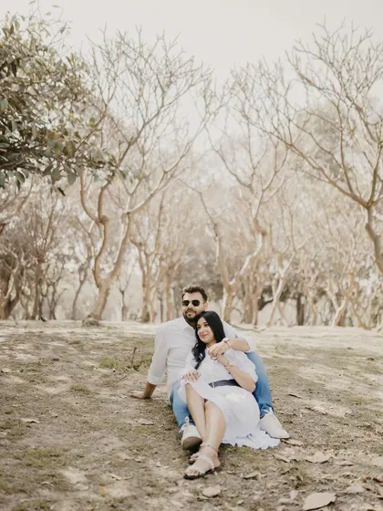 A wide shot of a couple relaxing in a sparse, beautiful landscape. This photo has a peaceful and minimalist feel, emphasizing their presence in nature.