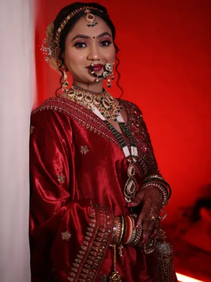 A dramatic and royal bridal portrait. The deep red velvet of her outfit and the intense lighting called for a makeup look that was equally powerful, with defined features and glowing skin.