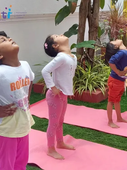 Children look up to the sky in a gentle backbend. Yoga helps them connect with their bodies and the world around them.