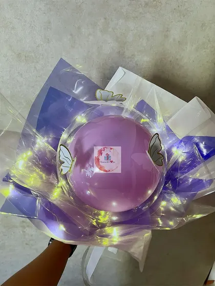 A beautiful bouquet-style hamper featuring a purple balloon decorated with butterflies and wrapped with fairy lights.
